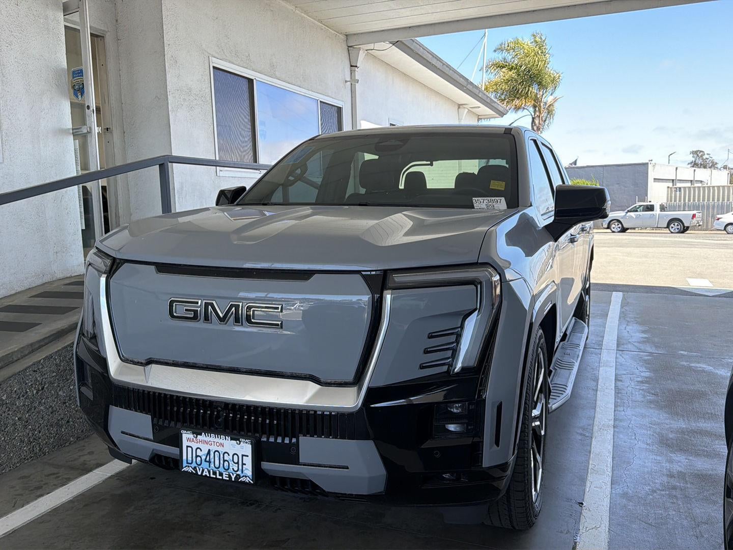 2024 GMC Sierra EV Denali Edition 1 in Thunderstorm Gray — front three-quarter view